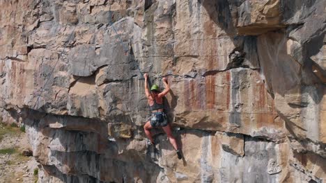Starke-Athletische-Bergsteigerin,-Die-Eine-Felswand-Erklimmt