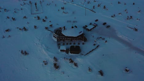 Aerial-view-of-the-Tuikku-restaurant-on-top-of-the-Levi,-in-gloomy-Lapland---tilt,-drone-shot