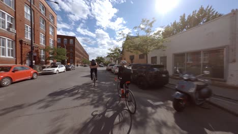 POV-Following-Cyclists-Along-Saint-Viateur-Street,-Montreal