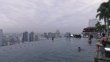 Tourists-Relaxing-By-Infinity-Pool-At-Marina-Bay-Sands-Hotel-In-Singapore