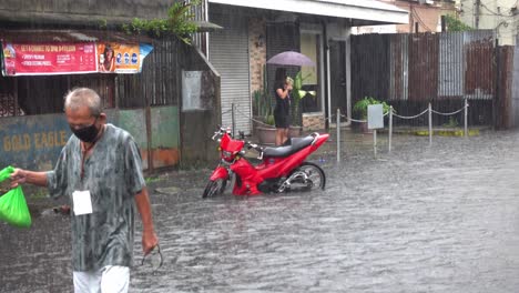 Un-Anciano-Caminando-Por-El-Agua-Hasta-Las-Rodillas-Mientras-Las-Carreteras-Comienzan-A-Inundarse-En-Surigao-Durante-La-Temporada-De-Lluvias