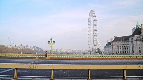 Quiet-and-empty-roads-at-rush-hour-in-London-in-Coronavirus-Covid-19-lockdown-with-deserted-streets-at-Westminster-Bridge-and-London-Eye,-no-traffic-or-cars-and-people-walking-for-commuting