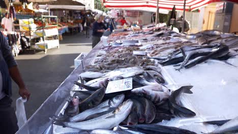 Fresh-Fishes-And-Seafood-Being-Sold-At-The-Street-Market-In-Rome,-Italy---tilt-up-shot