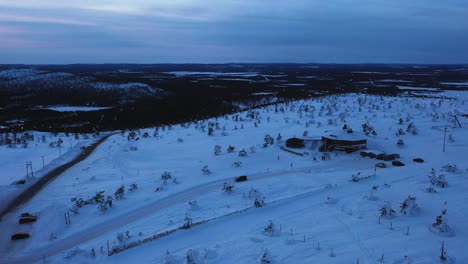 Aerial-view-of-a-car-and-the-Tuikku-restaurant,-in-Levi,-Lapland---tracking,-drone-shot