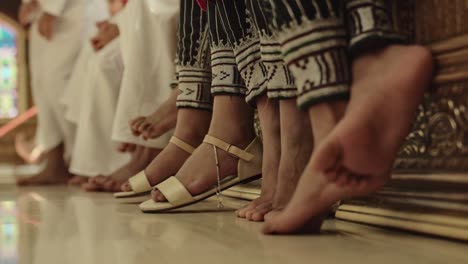 Detail-of-feet-of-middle-eastern-seated-girls-and-boys-in-Oman---Close-up-ground-level-shot