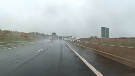 driver-point-of-view-northbound-the-M1-motorway-near-J35-in-United-Kingdom,-under-rain-on-a-bad-weather-day