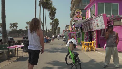 Cinematic-pov-slow-motion-shot-of-Caucasian-male-on-skateboard-in-Venice-Beach,-CA