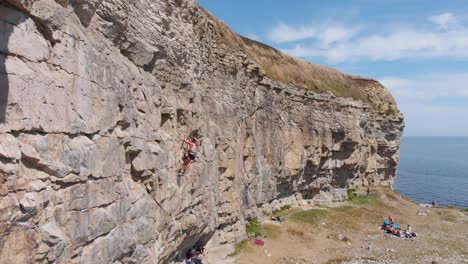 Aerial-Dolly-Out-of-Adrenaline-Rock-Climber-on-the-Dorset-Coast,-England