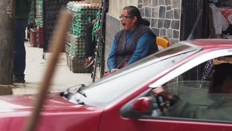 Local-Peruvian-Women-Sitting-On-Corner-Street-With-Traffic-Going-Past