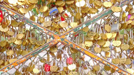 Close-up-vertical-panning-footage-of-the-symbolic-expression-of-love-and-affection-through-the-heart-shaped-padlocks-chained-to-a-fence-outside-the-Sacre-Couer-in-Paris-France