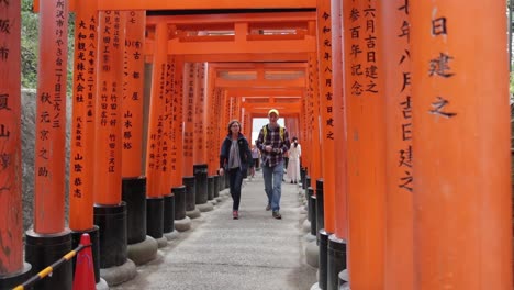 Touristen-Besuchen-Die-Roten-Shinto-Schreine-Mit-Japanischem-Text-Darauf-In-Kyoto