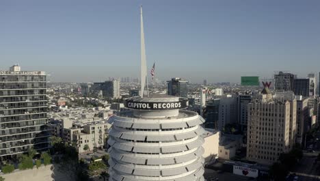 Top-of-Capitol-Records-Building-With-American-Flag,-Drone-Shot-of-Historic-Landmark-in-Hollywood,-Los-Angeles-CA-USA