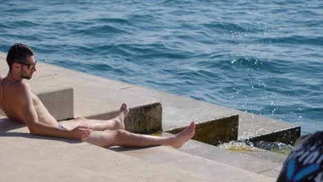 Mann-Nimmt-Sonnenbad-Auf-Der-Meeresorgeltreppe-Von-Zadar