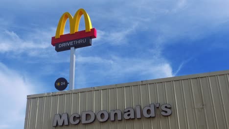 McDonald&#39;s-Drive-Thru-M-Logo-Beschilderung-Hoch-Oben-Am-Eingang-Auf-Dem-Dach-Vor-Blauem-Himmelshintergrund