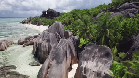 FPV-Drone-Shot-Through-Large-Granite-Boulders-and-Palm-Trees-on-Anse-Source-d'Argent-Beach,-La-Digue,-Seychelles