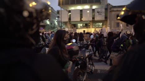 Polizisten-Mit-Helmen-Blicken-Auf-Eine-Menschenmenge-Von-Frauen,-Die-Während-Einer-Protestkundgebung-Zum-Internationalen-Frauentag-In-Quito,-Ecuador,-Marschiert
