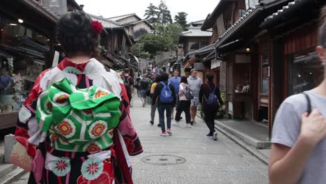 European-tourist-girl-walking-on-the-Gion-District-streets,-passing-by-the-camera