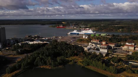 Aerial-view-around-a-Finnlines-cargo-ship-at-the-Naantali-harbor,-summer-in-Aland,-Finland---circling,-drone-shot