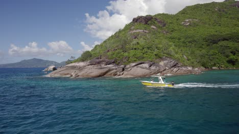 Drone-Rastreando-El-Taxi-Acuático-De-La-Felicidad-Desde-La-Playa-De-Anse-Major,-Mahé,-Seychelles