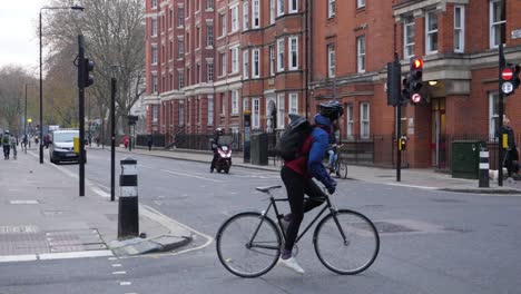 La-Gente-Anda-En-Bicicleta-Por-La-Calle-Londres,-Cámara-Lenta.