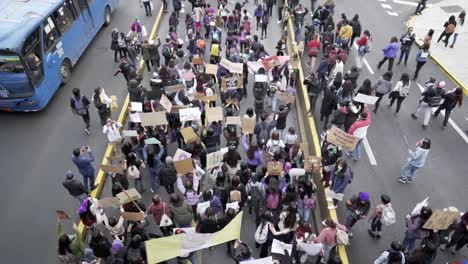 Hundreds-of-women-are-marching-and-holding-up-signs-of-protest-during-the-International-Women's-day-in-Quito,-Ecuador