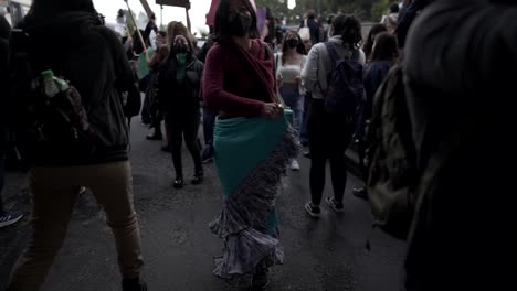 A-woman-is-dancing-and-moving-her-dress-while-marching-during-the-protest-in-the-International-Women's-day-in-Quito,-Ecuador