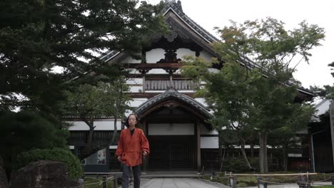 Chico-Japonés-Caminando-Frente-A-Una-Hermosa-Casa-Tradicional-Japonesa-En-El-Parque-De-Kyoto