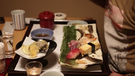 European-tourist-eating-Sushi-in-a-restaorant-in-Kyoto,-this-is-a-close-up-shot-of-the-sushi