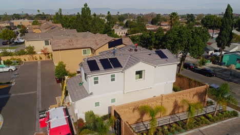 Arbeiter-Trägt-An-Einem-Sonnigen-Tag-Ein-Solarpanel-Auf-Dem-Dach-Eines-Modernen-Hauses-In-Los-Angeles,-Kalifornien