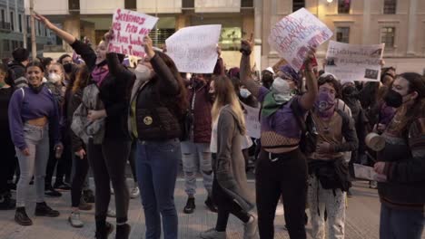 Varias-Mujeres-Saltan-Y-Cantan-Mientras-Sostienen-Cantos-De-Protesta-Durante-El-Día-Internacional-De-La-Mujer-En-Quito,-Ecuador.