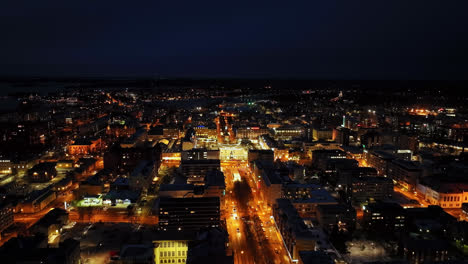Aerial-tracking-shot-of-the-illuminated-downtown-of-Vaasa,-night-in-Finland