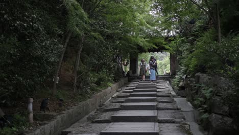 Tourist-walking-down-the-stairs-through-a-wooden-gate-in-Kyoto-park