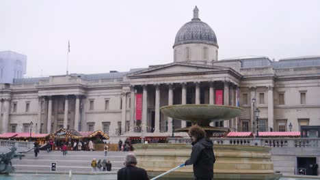 Man-clean-fountain-in-Trafalgar-square,-slow-motion