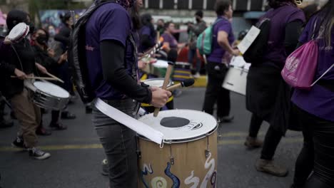 Women-are-playing-drums-while-marching-during-the-protest-in-the-International-Women's-day-in-Quito,-Ecuador