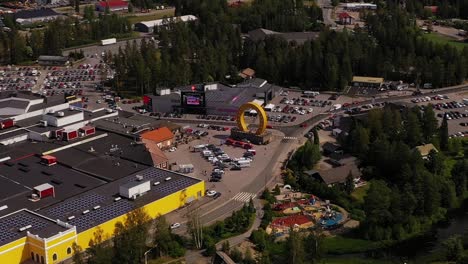 Aerial-view-around-the-horseshoe-statue-at-the-Keskisen-kylakauppa-department-store-in-Tuuri,-Finland---orbit,-drone-shot