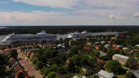 Aerial-view-of-cruise-liners-parked-at-the-Maarianhamina-port,-in-Aland,-Finland---pan,-drone-shot