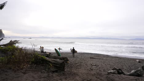 Surfistas-Con-Tablas-Caminando-Por-La-Playa-De-Sombrio,-Columbia-Británica,-Canadá