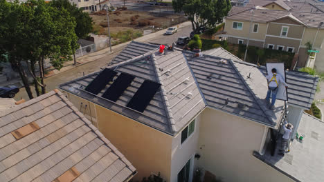 PV-Installateure-Bei-Der-Installation-Von-Photovoltaik-Solarmodulen-Auf-Dem-Schrägdach-Eines-Modernen-Hauses-In-Los-Angeles,-Kalifornien