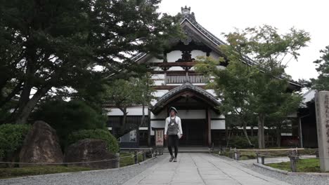 Un-Japonés-Con-Vestimenta-Tradicional-Camina-Frente-A-Un-Hermoso-Edificio-En-Kioto.