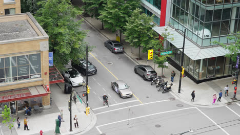 Urban-Street-Intersection-in-Vancouver-City-Downtown-District,-Cars-Traffic-and-Pedestrians-at-Crosswalk