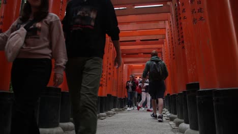 Una-Pareja-Y-Turistas-Caminando-Por-Los-Santuarios-Sintoístas-Rojos-En-Kioto,-Japón