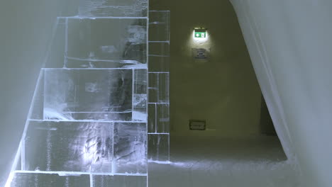 Crystal-Clear-Ice-Wall-Panels-in-Corridor,-Snow-Village,-Lapland-Hotel,-Panning-Shot
