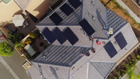 Top-Down-View-Of-Workers-Busy-Mounting-Solar-Panels-On-The-Roof-Of-A-Contemporary-House-In-Los-Angeles,-California-On-A-Sunny-Day