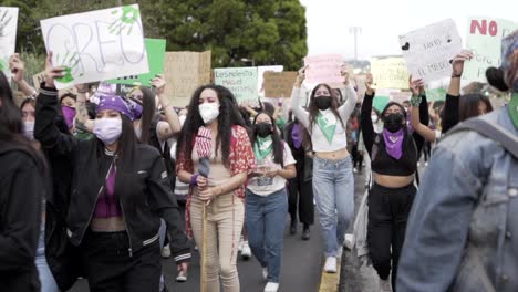 Frauen-Halten-Schilder-Mit-Protestbotschaften-Hoch,-Während-Sie-Während-Des-Protests-Am-Internationalen-Frauentag-In-Quito,-Ecuador,-Marschieren