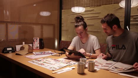 European-tourists-looking-at-the-japanese-menu-and-getting-prepared-to-order-food