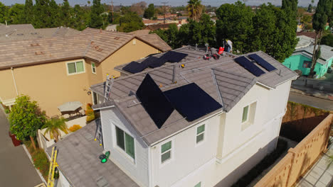 Arbeiter-Installieren-An-Einem-Sonnigen-Tag-In-Los-Angeles,-Kalifornien,-Sonnenkollektoren-Auf-Dem-Dach-Eines-Modernen-Hauses