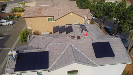 Arbeiter-Montieren-Und-Installieren-An-Einem-Sonnigen-Tag-Mehrere-Solarmodule-Auf-Dem-Dach-Eines-Modernen-Hauses-In-Los-Angeles,-Kalifornien