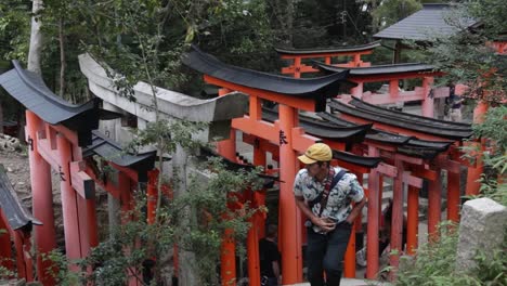 Tourist-taking-photos-of-the-red-shinto-shrines-in-Kyoto