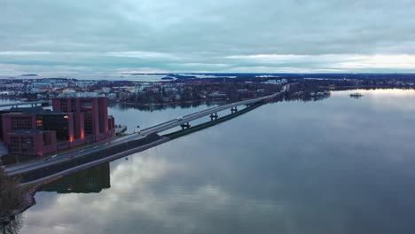 Aerial-drone-view-towards-traffic-on-road-51-and-the-Lauttasaari-district,-cloudy-fall-day,-in-Helsinki