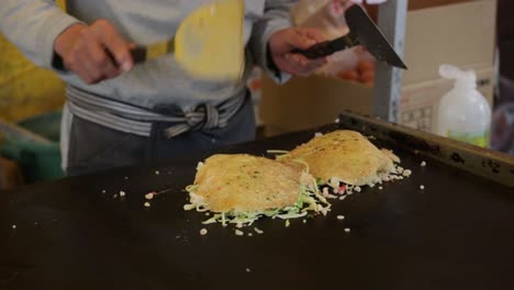 Nahaufnahme-Des-Kochs,-Der-In-Der-Bratpfanne-Okonomiyaki-Im-Hiroshima-Stil-Zubereitet